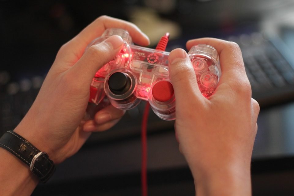 Hands holding controller in front of keyboard