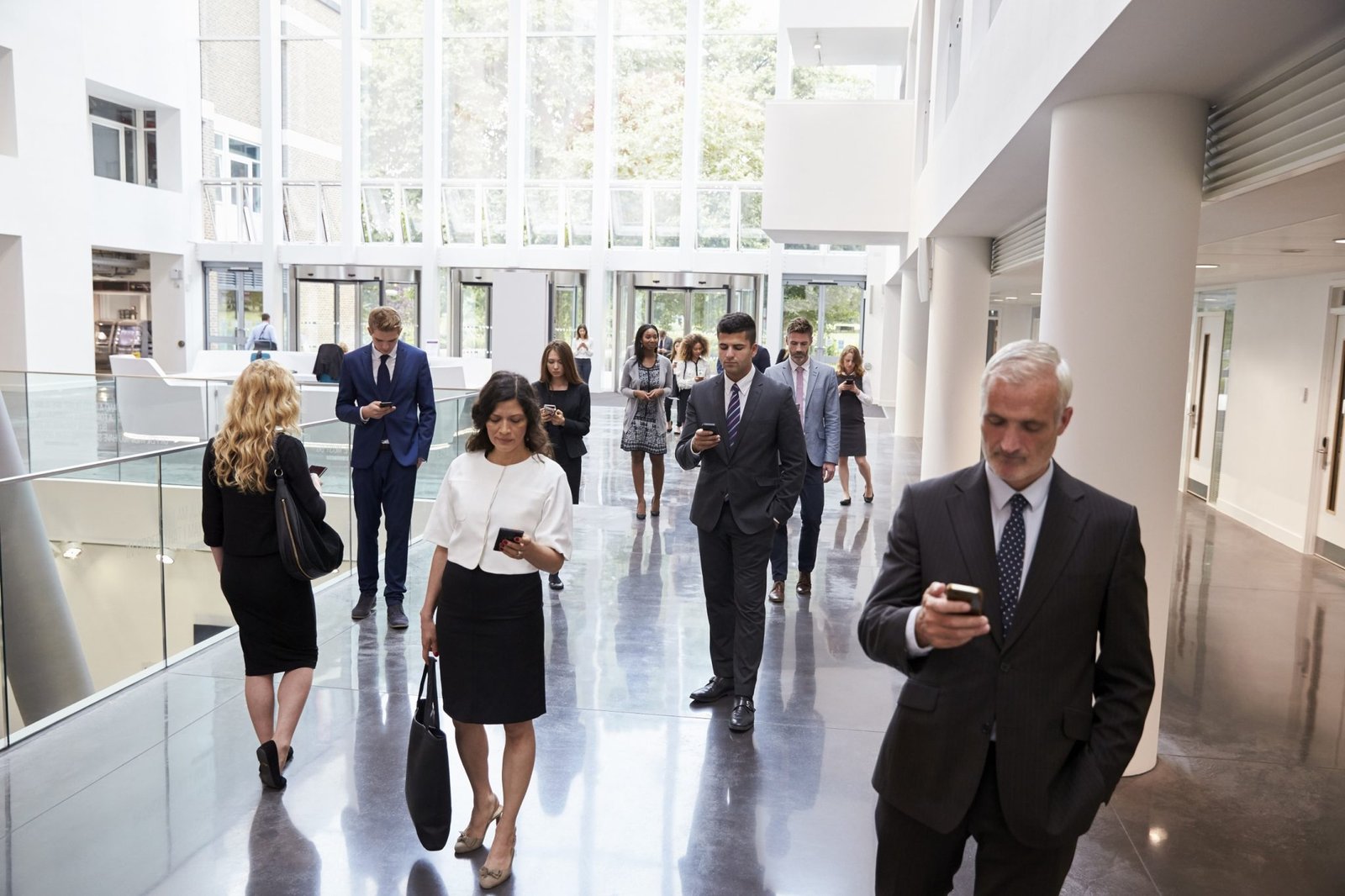 Business People using Technology in busy lobby