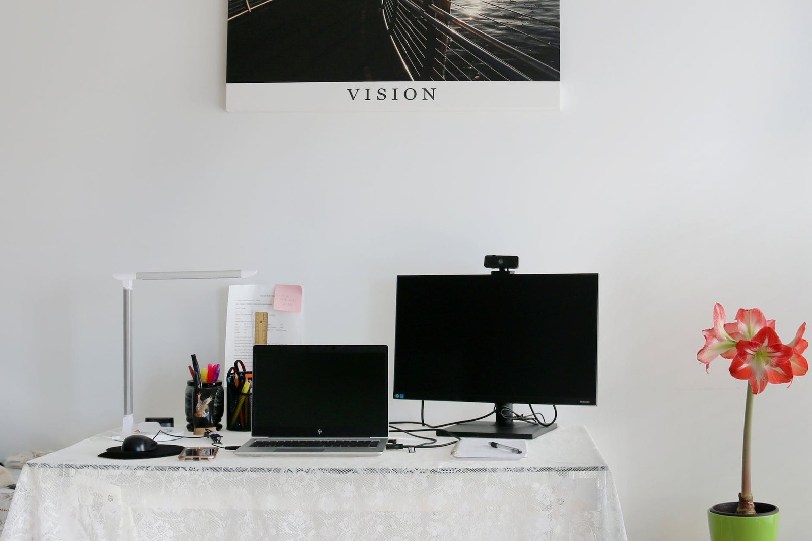 a laptop and monitor with a webcam in a workspace